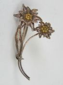 A silver filigree brooch in the form of two flowers, mark indistinct.