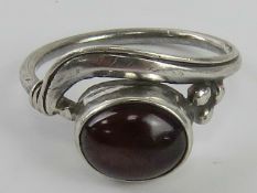 A handmade garnet ring in the Arts and Crafts style, no apparent hallmarks, size L-M.