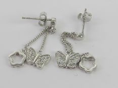 A pair of silver butterfly and floral drop earrings, stamped 925 with 925 silver butterfly backs,