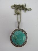 A silver and turquoise pendant having CZ stone surrounding the central cabachon, total diameter 4.