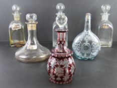A ruby glass decanter with clear glass stopper together with a quantity of other decanters and