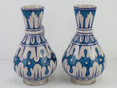 A pair of pottery vases in blue and white ground, each standing 22cm high.