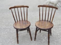 A good pair of circular seated spindle back chairs raised over ring turned legs, each 41cm dia.