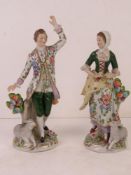 A pair of Continental figurines being male and female each with sheep to foot, 18cm high.
