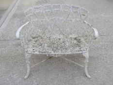 A white painted cast metal two seated garden bench, legs united by X shaped stretcher, 96cm wide.