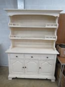 A 20th century cream painted Welsh dresser having twin shelves with pediment over,