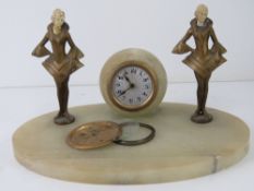 An art deco onyx desk clock having central garniture a/f flanked by two female figurines (a/f) with