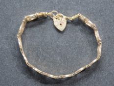 A 9ct gold four bar gate link bracelet having heart padlock clasp, hallmarked 375, 4.5g.