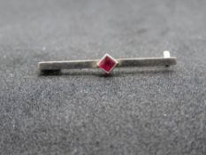 A well made yellow metal vintage brooch having central diamond shaped red stone in white metal