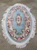 An oval woolen rug, 177 x 115cm.