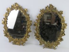 A pair of heavy brass framed wall mirrors having ivy design, each approx 48 x 36cm.