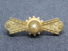 A 9ct gold brooch having central seed pearl and floral pattern upon, hallmarked 375, 3.4g.