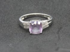 A 9ct white gold and amethyst ring, central cushion cut lilac stone, stamped 9k, size P, 2.7g.