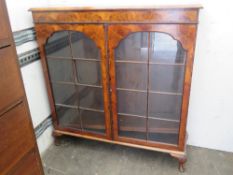 A fine Edwardian walnut twin glazed door bookcase raised over short cabriole legs,