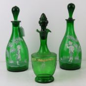 A pair of Mary Gregory style green glass decanters standing 30cm high together with another.