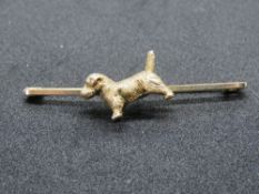A heavy early 20th century bar brooch having cast figure of a dog upon,