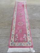 An oval woolen runner, 328 x 76cm.