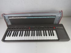 A Bontempi Minstral synthesizer together with a miniature hurdy-gurdy in box. Two items.