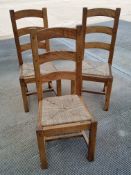 Three contemporary oak framed dining chairs.
