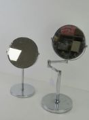 Two chromed magnifying shaving mirrors.