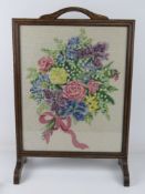 A wool work fire screen depicting bouquet of flowers.