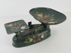 A hand painted canal or barge wear type set of scales in green ground with floral pattern upon.