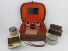 A vintage travelling vanity case with accessories.
