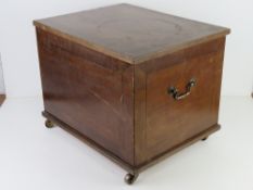 An early 20th century log box raised over brass castors, 48 x 38.5 x 38.5cm.