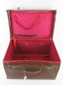 An antique silk lined leather travelling case, slightly a/f, with twin locks,