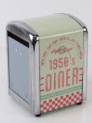 A contemporary metal serviette dispenser.