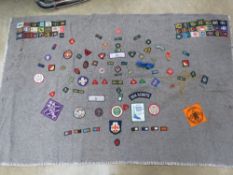 A Scouts blanket having numerous patches / badges upon inc 1977 Queen's Silver Jubilee, Boy Scouts,