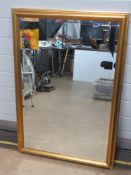 A large contemporary bevelled edge wall mirror in gold painted frame measuring 100 x 68.5cm.