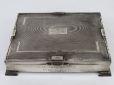 A HM silver cigar box raised over stepped feet and having Art Deco geometric pattern throughout,