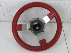 A red leather covered steering wheel marked 'Astrali 1978 patent no 2022764 REG. DES. APP.