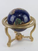 A tabletop blue lapis ocean gemstone globe,