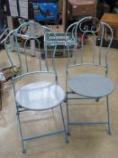 A pair of blue and grey painted metal bistro chairs.