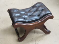 A brown upholstered foot stool having x-shaped frame 57 x 44 x 34cm.