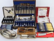 An oak canteen containing a quantity of plated cutlery inc meat fork and knife, servings spoons,