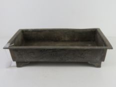A Chinese rectangular shaped metal planter having three toe dragon and clouds to one side and