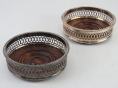 A pair of Georgian style silver plated mahogany based wine stands having fretted sides, 13.5cm dia.