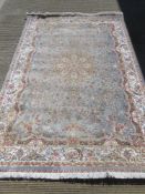 A silk and wool rug in pale blue and cream ground having floral pattern upon and measuring 160 x