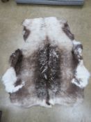 A reindeer hide rug measuring approx 130 x 110cm.