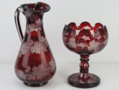 A ruby glass 'Bacchus' claret jug 27cm high, together with a similar footed table centre piece.