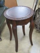 A contemporary occasional table having carved floral border and raised over shaped legs, 41cm dia,