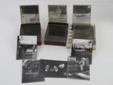 A quantity of black and white magic lantern type projector slides.