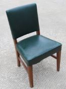 A single green leather office chair raised over mahogany frame.