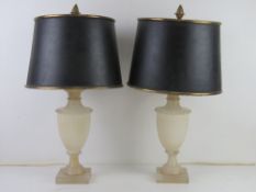 A pair of alabaster table lamps in the form of classical urns having black and gilt painted metal