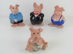A set of four NatWest pig money banks by Wade, three having original black NatWest stoppers.