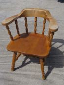 A contemporary smokers type bow back armchair having ring turned decoration throughout.