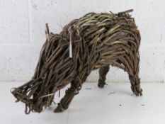 A wicker garden figurine of a pig 52cm in length. a/f.